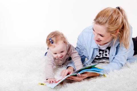 Mother and young baby looking at book together