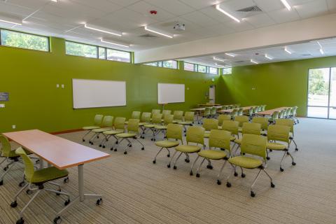 Large room with tables, chairs, whiteboard