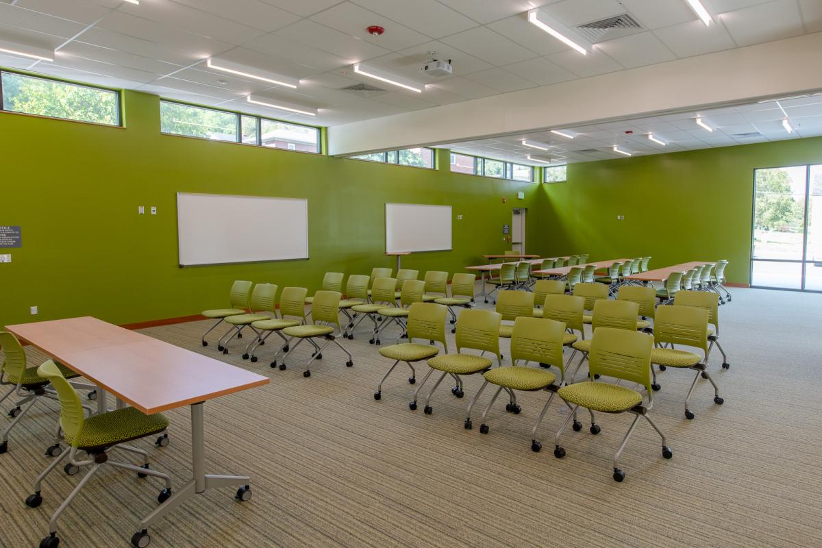 Large room with tables, chairs, whiteboard